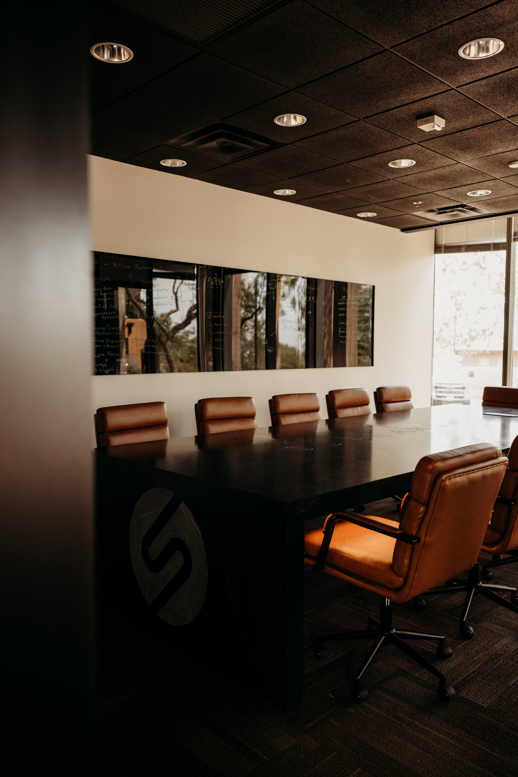 Custom stone executive conference table by AZ Boardrooms in Scottsdale, Arizona, with black marble top and executive leather seating